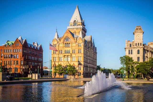 Downtown Syracuse with a view of historic buildings and the fountain at Clinton Square